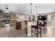 Open-concept kitchen with stainless steel appliances, bar seating, and ample counter space at 17574 W Gelding Dr, Surprise, AZ 85388