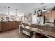 An open kitchen with stainless steel appliances, granite counters, tile floors, and a breakfast bar at 17574 W Gelding Dr, Surprise, AZ 85388
