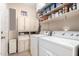 Efficient laundry room with modern washer and dryer, ample storage cabinets, and practical layout at 17574 W Gelding Dr, Surprise, AZ 85388