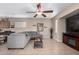 Comfortable living room with tile flooring, ceiling fan, and an entertainment center at 17574 W Gelding Dr, Surprise, AZ 85388