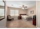 Spacious main bedroom featuring a ceiling fan, neutral colors, and tile flooring at 17574 W Gelding Dr, Surprise, AZ 85388