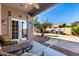 Charming covered patio with outdoor seating, grill, and landscaped backyard view at 17574 W Gelding Dr, Surprise, AZ 85388