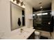 Modern bathroom featuring a sleek glass shower, black tiled wall, and quartz countertop at 17594 N 98Th Way, Scottsdale, AZ 85255