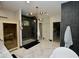 Modern bathroom featuring a glass-enclosed shower, marble floors, and a contemporary chandelier at 17594 N 98Th Way, Scottsdale, AZ 85255