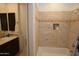 Bright bathroom featuring a shower-tub combo with stylish tile and a dark wood vanity at 17594 N 98Th Way, Scottsdale, AZ 85255