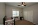 Cozy bedroom features a ceiling fan, bright shutters, a crib, and a closet at 17594 N 98Th Way, Scottsdale, AZ 85255