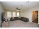 Spacious living room with neutral carpet, a dark leather sectional, and bright window shutters at 17594 N 98Th Way, Scottsdale, AZ 85255