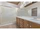 Bathroom featuring a double sink vanity, large mirror, and glass enclosed shower at 18155 N Sterling Dr, Surprise, AZ 85374
