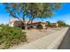Inviting desert home with mature landscaping, tile roof, and a spacious three-car garage, creating great curb appeal at 18155 N Sterling Dr, Surprise, AZ 85374
