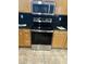The kitchen features an oven, microwave and wooden cabinets with contrasting black granite countertops at 18155 N Sterling Dr, Surprise, AZ 85374