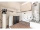 Utility room with water heater, cabinets, shelving, and brick tiled flooring at 18155 N Sterling Dr, Surprise, AZ 85374