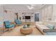 Bright, open-concept living room with a white sofa, blue chairs, and large built-in entertainment center at 18155 N Sterling Dr, Surprise, AZ 85374