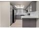 Bright and airy kitchen with gray cabinets, stainless steel appliances, quartz countertops and a skylight at 1905 E University Dr # 162, Tempe, AZ 85288