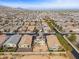 An aerial view reveals a neighborhood with well-maintained houses and landscaping nestled against a backdrop of scenic mountains at 19937 W Heatherbrae Dr, Litchfield Park, AZ 85340