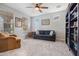 Cozy living room with ceiling fan, carpet, and a bookshelf perfect for reading or entertainment at 19937 W Heatherbrae Dr, Litchfield Park, AZ 85340