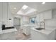 Bright, modern kitchen featuring white cabinets, a skylight, stainless steel appliances, and marble countertops at 2004 W Kristal Way, Phoenix, AZ 85027