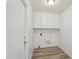 Laundry room with overhead cabinets, plumbing hookups, and wood-look flooring at 2004 W Kristal Way, Phoenix, AZ 85027
