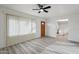 Bright living room with wood-look flooring and a ceiling fan, leading to a kitchen at 2004 W Kristal Way, Phoenix, AZ 85027
