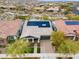 Aerial view of a home with solar panels, manicured landscaping, paved driveway, and neighborhood at 20584 W Hillcrest Blvd, Buckeye, AZ 85396
