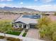 Aerial view of the home featuring solar panels, well-manicured landscaping, a front porch, and a paved driveway at 20584 W Hillcrest Blvd, Buckeye, AZ 85396