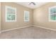 Bright, vacant bedroom with carpeted floor and multiple windows fitted with white, plantation shutters at 20584 W Hillcrest Blvd, Buckeye, AZ 85396