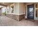 Inviting covered front porch showcasing stone accents and a secure metal screen door at 20584 W Hillcrest Blvd, Buckeye, AZ 85396