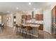 Modern kitchen features an island with bar seating, stainless steel appliances, and tile backsplash at 20584 W Hillcrest Blvd, Buckeye, AZ 85396