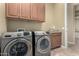 Laundry room with side by side washer and dryer, granite counters and wood cabinets for storage at 20584 W Hillcrest Blvd, Buckeye, AZ 85396