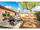Backyard featuring a stainless steel grill, patio area, and mature trees for shade at 21640 N 48Th St, Phoenix, AZ 85054