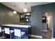 Basement bar area with white counter, shelving, blue cabinetry and seating at 2423 W Bramble Berry Ln, Phoenix, AZ 85085