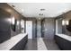 Modern bathroom with sleek gray cabinets, dual sinks, elegant mirrors, and a glass-enclosed shower for a spa-like feel at 2423 W Bramble Berry Ln, Phoenix, AZ 85085