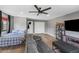 Spacious room with a ceiling fan, gray walls, and wood flooring; ideal for relaxing or entertaining with a cozy couch at 2423 W Bramble Berry Ln, Phoenix, AZ 85085