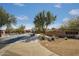 Inviting Desert Crown community entrance featuring lush desert landscaping, secure entry gate, and community signage at 2423 W Bramble Berry Ln, Phoenix, AZ 85085