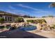 A backyard pool is accented with boulders and a sunning area with lounge chairs for relaxing outdoors at 24517 N 77Th St, Scottsdale, AZ 85255