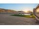 Wide shot of a backyard with desert landscape, a pool, and a shaded seating area at 3211 E Ian Dr, Phoenix, AZ 85042