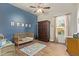 Bright ' bedroom featuring a blue accent wall, wooden flooring, and a ceiling fan at 3211 E Ian Dr, Phoenix, AZ 85042