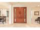 Elegant foyer with a grand wooden door, travertine flooring, and open living spaces at 3211 E Ian Dr, Phoenix, AZ 85042
