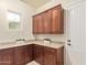 Laundry room with granite counters, cabinets, a window and white door, with ample storage at 3211 E Ian Dr, Phoenix, AZ 85042