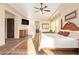 Bright main bedroom with wood floors, ceiling fan, furniture, and large windows with views at 3211 E Ian Dr, Phoenix, AZ 85042