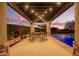 Covered outdoor patio features dining area with string lights and a pool view at 3211 E Ian Dr, Phoenix, AZ 85042