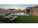Stunning backyard pool with covered patio, lush lawn, and comfortable outdoor seating at sunset at 3211 E Ian Dr, Phoenix, AZ 85042