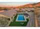 Aerial view of backyard pool with turf, covered seating area and a view of desert mountain terrain at 3211 E Ian Dr, Phoenix, AZ 85042