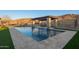 Beautiful pool with a pergola and water features, surrounded by manicured turf and landscaping at 3211 E Ian Dr, Phoenix, AZ 85042