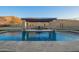 Pool with water features and a pergola providing shade for outdoor dining, set against a desert landscape at 3211 E Ian Dr, Phoenix, AZ 85042