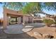 View of covered back patio and landscaped backyard with mature tree and desert landscaping at 3517 N Paseo Del Sol --, Mesa, AZ 85207