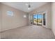 Main bedroom featuring a ceiling fan, neutral carpet, and sliding glass doors to the outdoor space at 3517 N Paseo Del Sol --, Mesa, AZ 85207