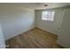 Cozy bedroom featuring hardwood floors and a window allowing natural light to illuminate the space at 3807 N 64Th Dr, Phoenix, AZ 85033