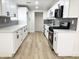 Updated kitchen with stainless steel appliances, light wood floors, and gray tile backsplash at 3807 N 64Th Dr, Phoenix, AZ 85033