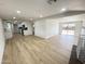 Open-concept living room featuring light wood floors, white walls, and access to the backyard at 3807 N 64Th Dr, Phoenix, AZ 85033
