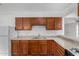 Modern kitchen featuring wood cabinets, stainless steel sink, and granite countertops at 3821 W Verde Ln, Phoenix, AZ 85019